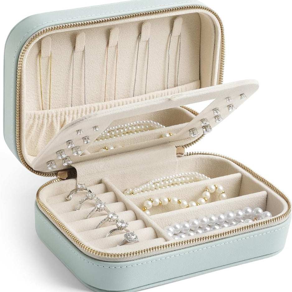 Mint leather travel jewelry case, open, with rings, earrings and necklaces inside