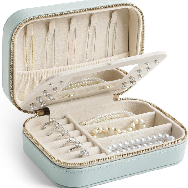 Mint leather travel jewelry case, open, with rings, earrings and necklaces inside