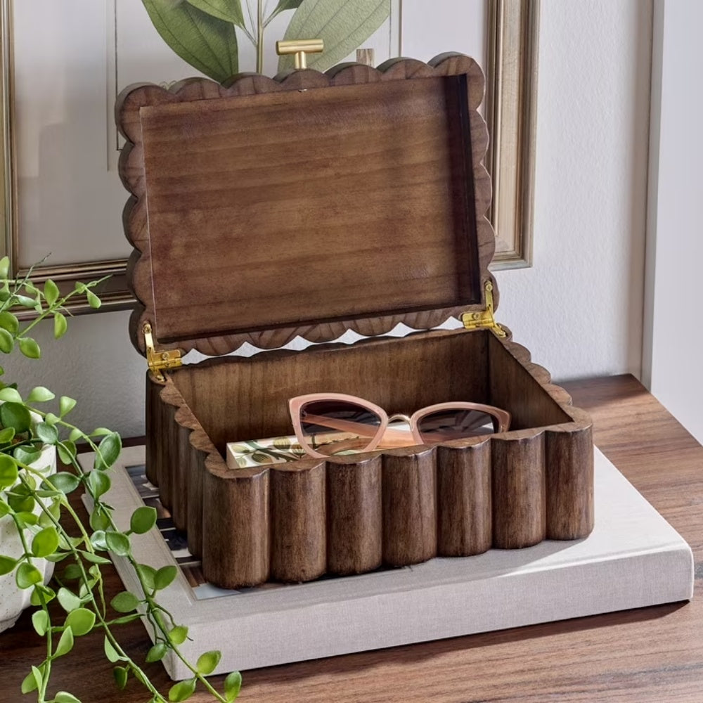 Open scalloped wooden jewelry box holding sunglasses and jewelry
