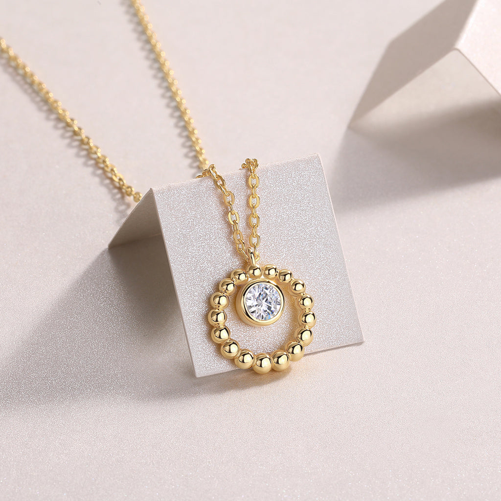 Beaded halo moissanite pendant on a display stand