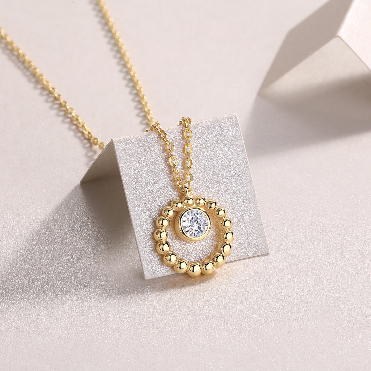 Beaded halo moissanite pendant on a display stand