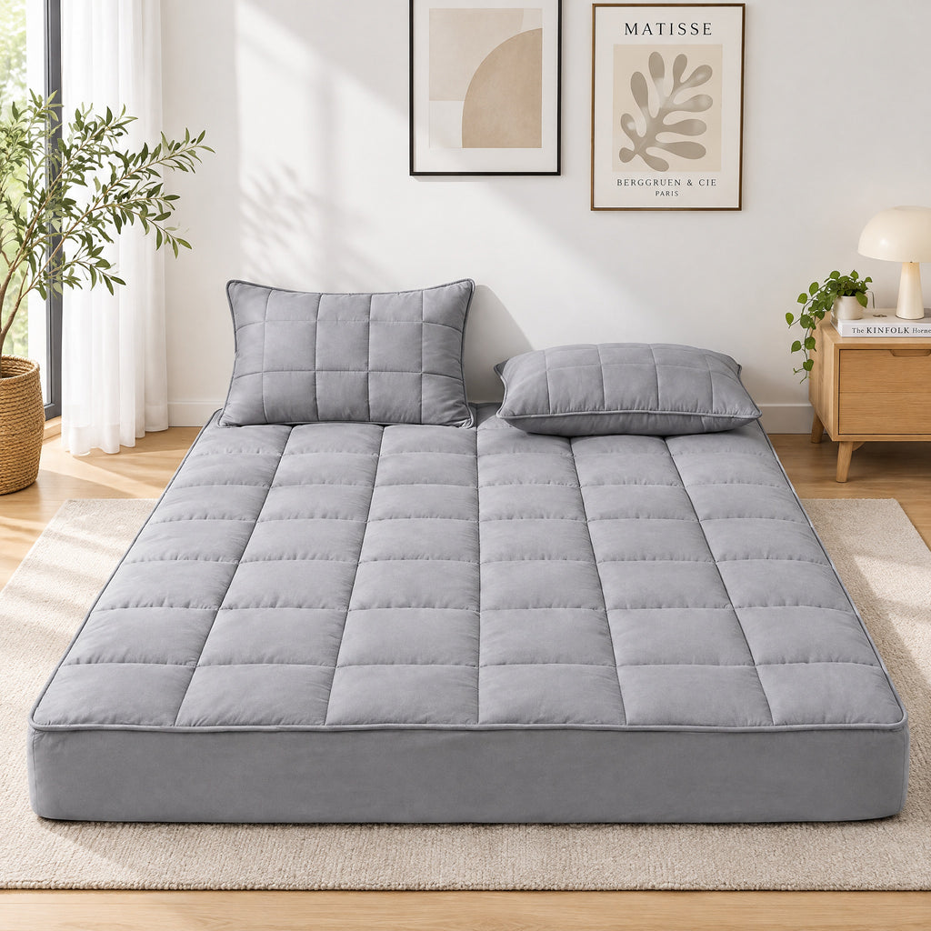 Deep-pocket quilted mattress pad on a bed, white