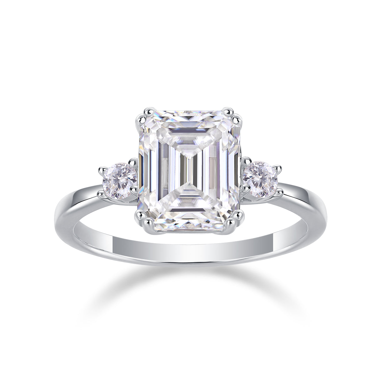Emerald-cut moissanite three-stone ring on a white background